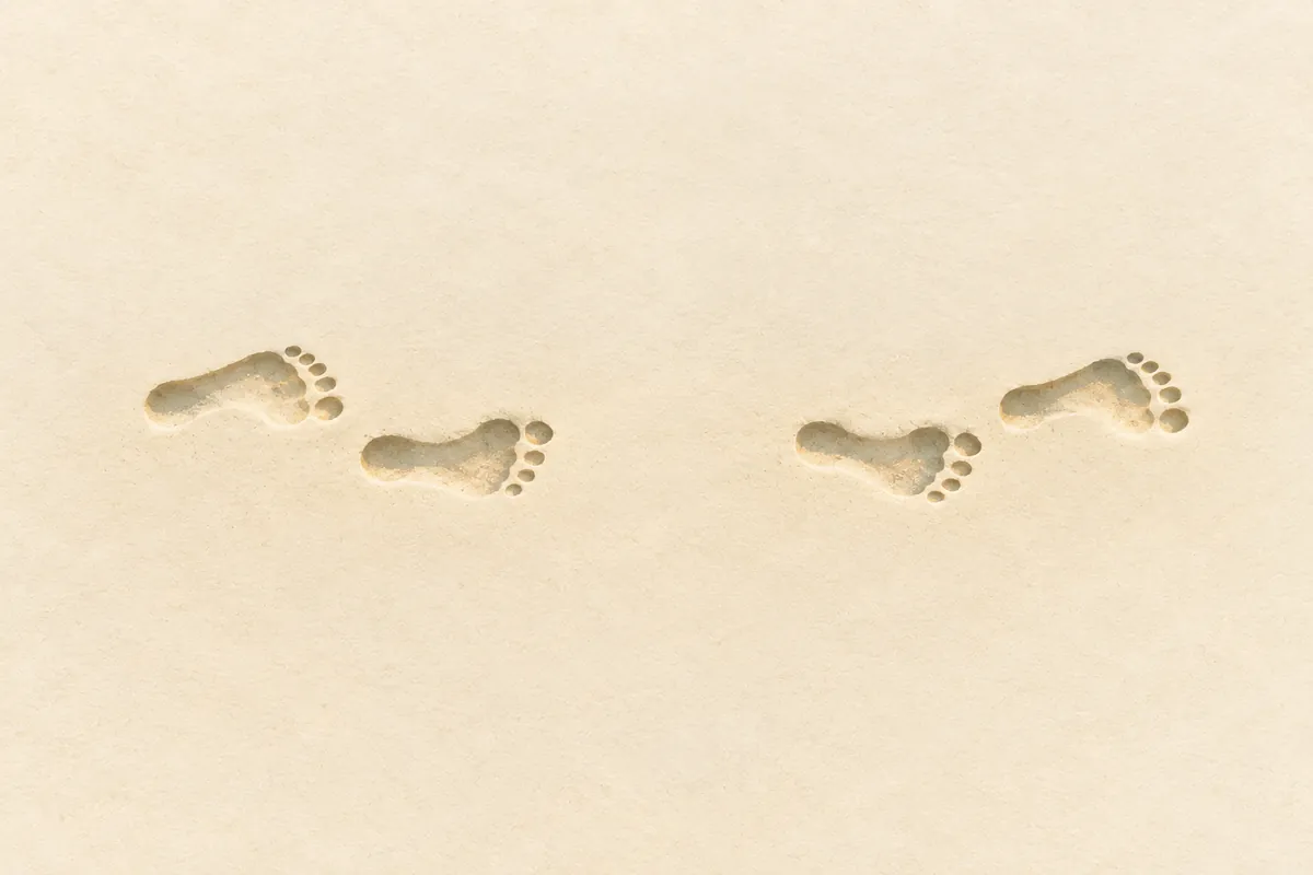 Illustration of footprints crossing sand, stopping for a short gap, then continuing in the same direction